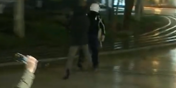 Protestuesi e ndjek me çadër në dorë, efektivi i policisë largohet me vrap (Video)