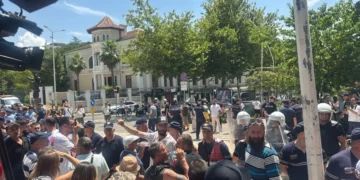 Policia shtyn me forcë protestuesit për t’i hapur rrugë Albana Koçiut, qytetarët i gjuajnë me vezë