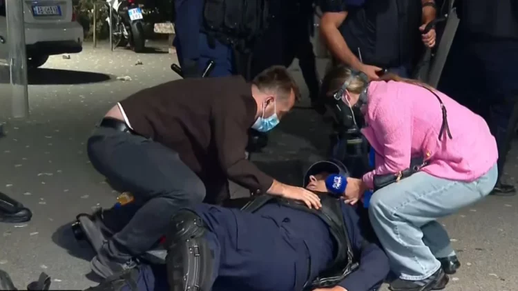 Momenti kur protestuesit ndihmojnë policin e shtrirë për tokë