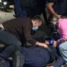 Momenti kur protestuesit ndihmojnë policin e shtrirë për tokë